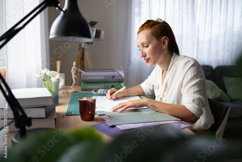 A white woman working from home writing at a desk in Galicia, spain