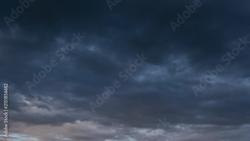 Ominous dark thunderclouds moving fast across the sky, impending rain storm time-lapse.