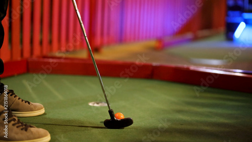 Принти на полотні Close-Up of Player Preparing to Putt Orange Ball in Mini Golf
