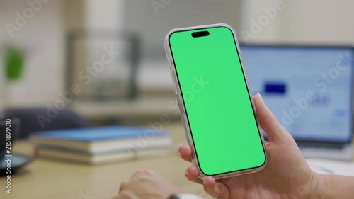 Close-up Of Smartphone With Green Mock-up Screen In Women's Hands On Desktop Background. Woman Using Mobile Phone, Browsing Internet, Social Networks, Financial Reports