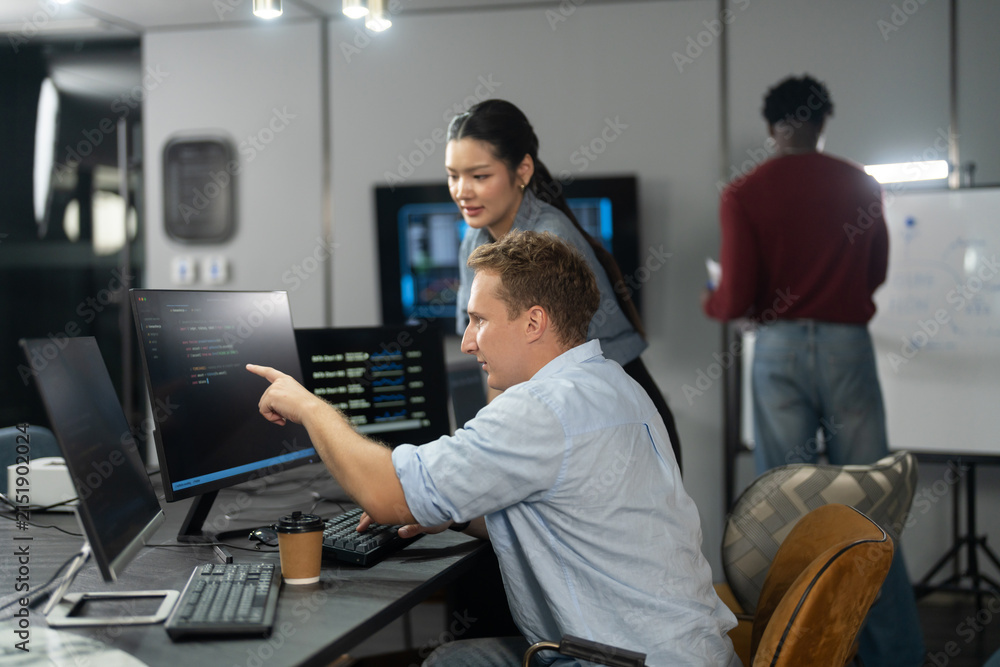 Fototapeta premium Diverse male and female programmers teamwork coding collaboration in modern IT office, Happy software developer team analyzing data on computer monitors, Technology business startup innovation