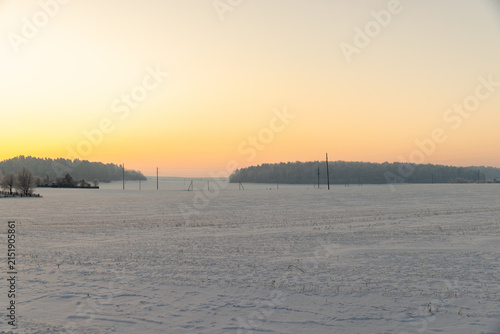 a beautiful sunset or sunrise on a snow-covered field in winter, wind ripples