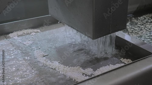Close up: fast water flow with recycled plastic granules, pellets for filtration, separation the plastic material - plastic pelletizer recycling machine. Reuse, waste reduction and sustainable concept