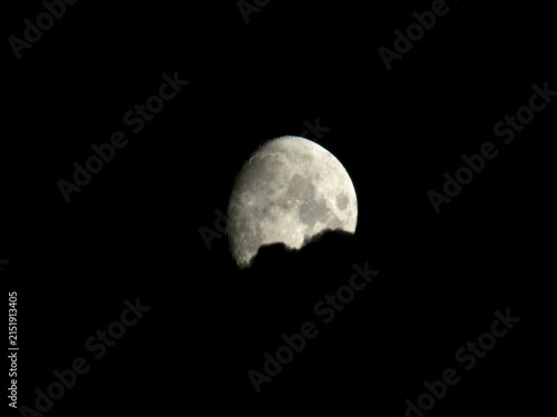 Konstfotografi Waxing gibbous moon behind dark dense cloud silhouette in night sky