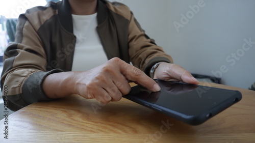 Professional business and financial planning concept featuring an entrepreneur working with a laptop, calculator, smartphone, and digital tablet at a wooden desk
