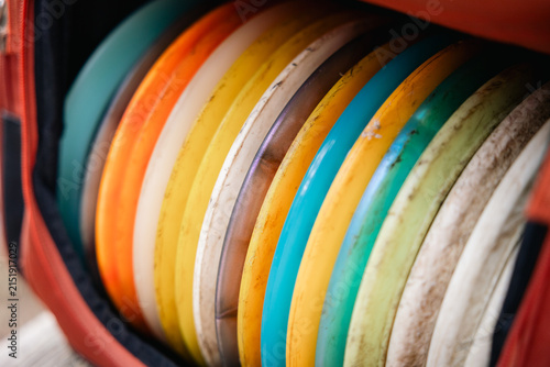 close up of orange disc golf bag full of discs