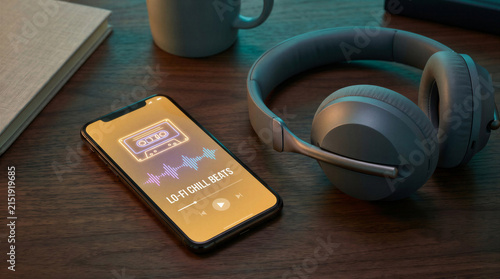 Smartphone playing lo-fi music beside headphones and coffee mug  