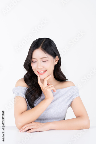 Shy young asian fingers touching chin with healthy facial skin and glowing natural makeup for beauty and cosmetics concept.