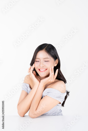 Shy young asian fingers touching cheek with healthy facial skin and glowing natural makeup for beauty and cosmetics concept.
