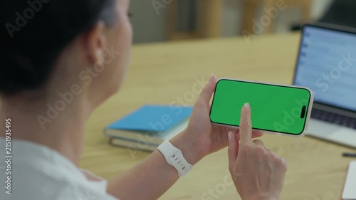 Woman Using Smartphone with Green Screen Chroma Key at Her Desk in Office. Woman Using Mobile Phone, Browsing Internet, Social Networks, Financial Reports