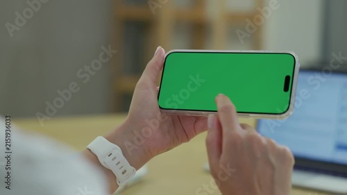 Woman Using Smartphone with Green Screen Chroma Key at Her Desk in Office. Woman Using Mobile Phone, Browsing Internet, Social Networks, Financial Reports