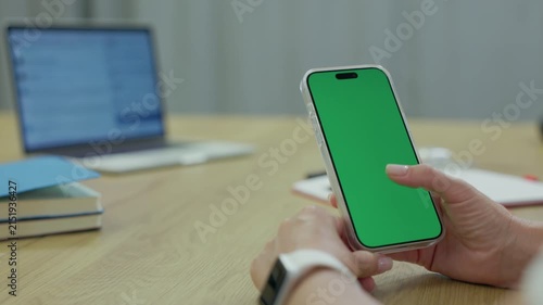 Woman Using Smartphone with Green Screen Chroma Key at Her Desk in Office. Woman Using Mobile Phone, Browsing Internet, Social Networks, Financial Reports