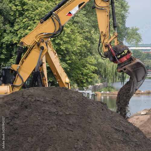EXCAVATORS - Construction machines are working on the river