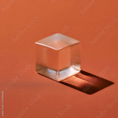 Fototapeta samoprzylepna Frosted Glass Cube on Terracotta Surface Minimalist Abstract