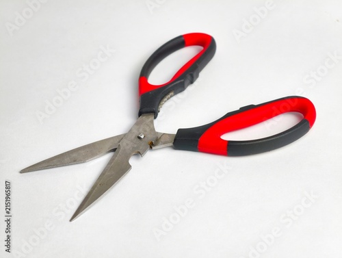 Foto Open multi-purpose kitchen scissors with stainless steel blades, red and black ergonomic handles, and notch functions, isolated on a white surface