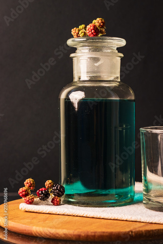 Fotografía Close up of blackberries and a glass of  blue tea (butterfly pea flower tea)
