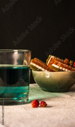 Foto Close up of a bowl with jelly candies, blackberries and a glass of  blue tea (butterfly pea flower tea) in the foreground