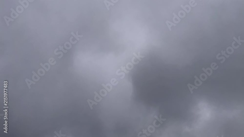 Dark storm clouds fast moving across an overcast sky timelapse. Atmospheric time lapse of dense gray clouds creating a dramatic natural weather background. 