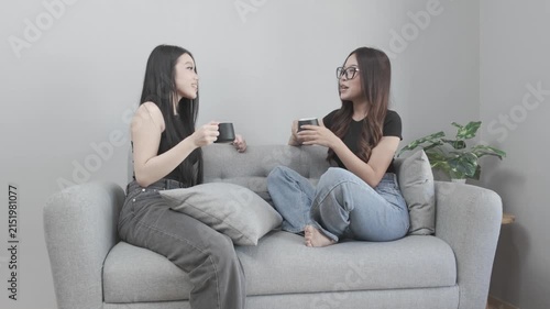 Two Asian Women Enjoying Coffee and Having a Fun Conversation at Home