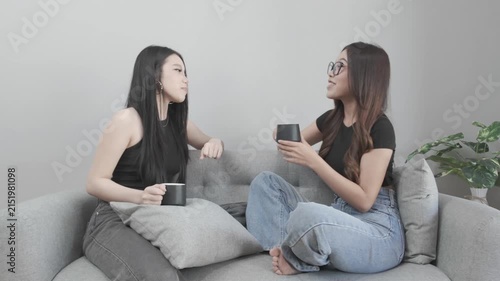 Two Asian Women Enjoying Coffee and Having a Fun Conversation at Home