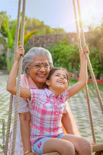Grandmother swinging her daughter