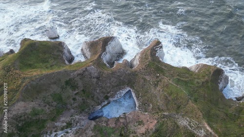 Aerial top down view of waves crashing against chalk cliffs at Flamborough Head, England