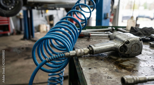 Mechanic's Air Hose and Impact Wrench on Workbench in Garage