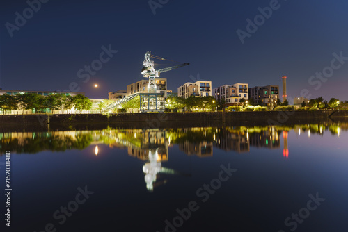 Modern new build properties by the water in Offenbach am Main harbor bey night, Hesse: Development of a new residential area in a city with condominiums and apartments