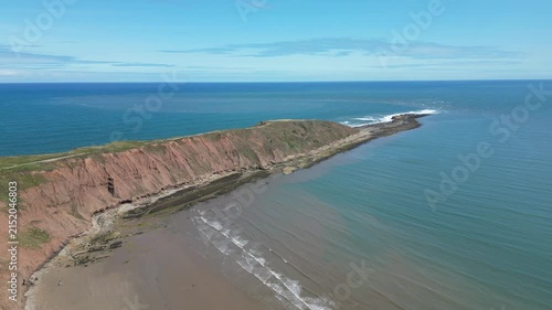 Aerial push in view of Filey Brigg peninsula and dramatic cliffs, North Yorkshire, England