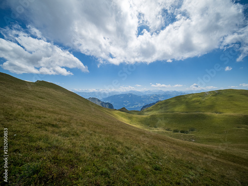 Panoramic alpine meadows and rolling green hills overlooking distant peaks - Bernese Oberland, Switzerland