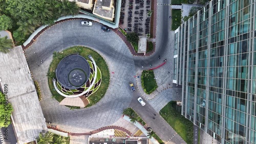 Modern glass office building with a circular landscaped courtyard seen from above