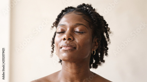 Portrait of a peaceful young Black woman with eyes closed in meditation.