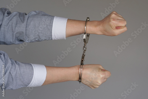 Фотография Two woman's arms in handcuffs, clenched fists