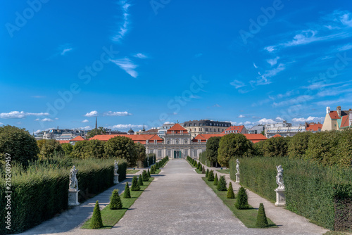 Symmetrical alley with statues and hedges in Belvedere gardens leading to Lower Belvedere palace in Vienna