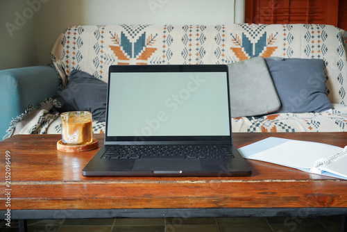 Laptop Workspace with Coffee and Notebook on Wooden Table at Home