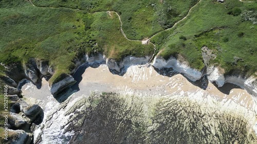 Aerial top down tracking shot of chalk cliffs and beach at Flamborough Head, England