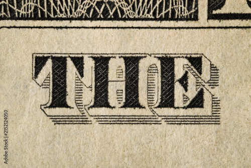 Macro detail of a one-dollar banknote. Engraved lettering, fine linework and aged paper texture visible in close-up.