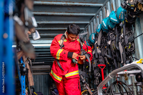 Foto An intense male firefighter putting on his protective bunker gears and smoke mas