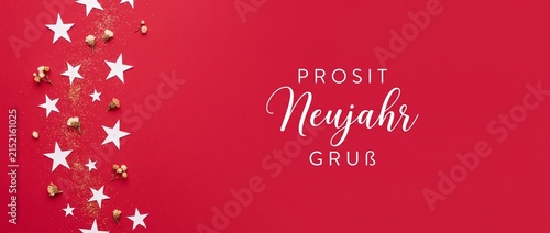 New year background red festive star decoration banner with prosit neujahr gruss typography text, flat lay copy space template for German happy new year celebration greeting card poster design.