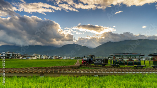 Photography Vintage tourist train on Xizhou pastoral farmland, rural plateau landscape Dali