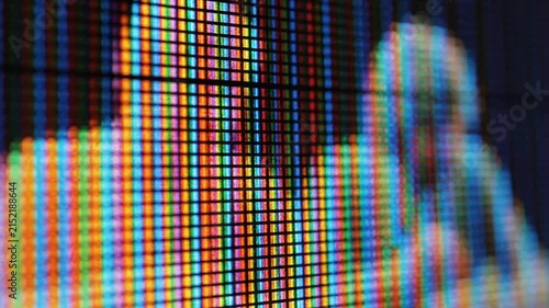Macro view of a digital screen showing blurred human silhouettes
