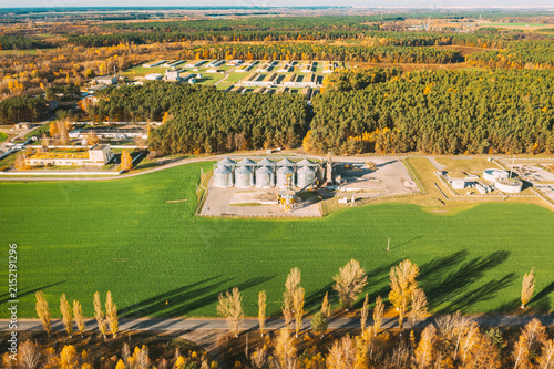 Obraz na plátně Aerial view modern granary, grain-drying complex, commercial grain or seed silos in sunny autumn rural landscape