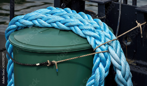 Принти на полотні Thick Blue Mooring Rope Coiled on Harbor Bollard