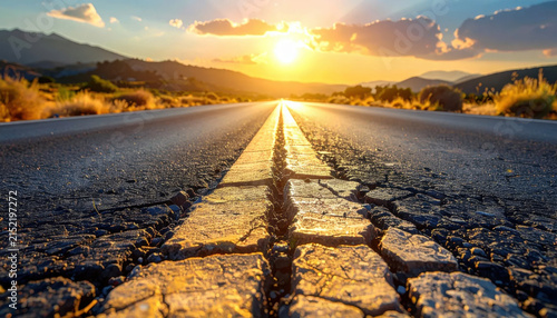 Sunset road with cracked asphalt and golden light