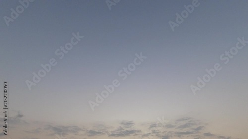 Time-lapse of a calm blue-grey sky with small clouds at the bottom. Ample negative space for text and graphic overlays. Peaceful nature background.