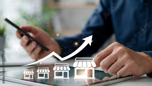 Person using tablet to manage growing business retail franchise with increasing revenue and expansion icons business franchise management expansion strategy corporate development entrepreneur