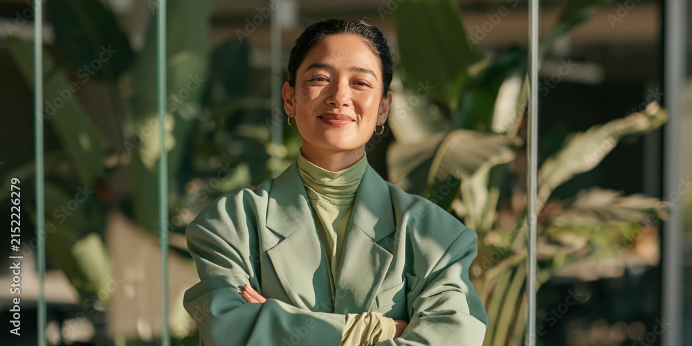 Obraz premium Confident young woman in mint green suit with indoor plants background for corporate profile and website banner design