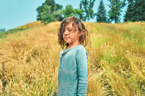 Canvas Print Close-up portrait of a boy with wet messy hair on a golden hillside