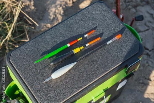 Foto Fishing floats and tackle accessories arranged on a tackle box outdoors near water