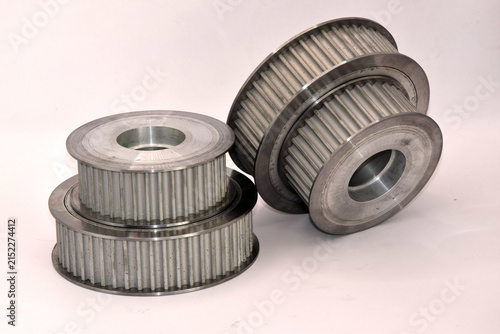 Set of precision machined aluminum and steel synchronous pulleys, spur gears, and drive components used in industrial machinery engineering and mechanical power transmission systems.